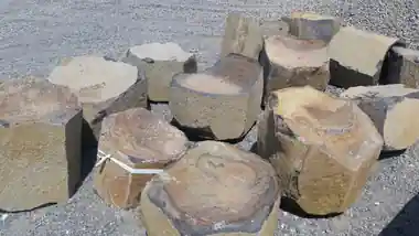Carved basalt bowls set out on the gravel in the yard