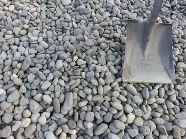 1 1/2 drain rock with a shovel
