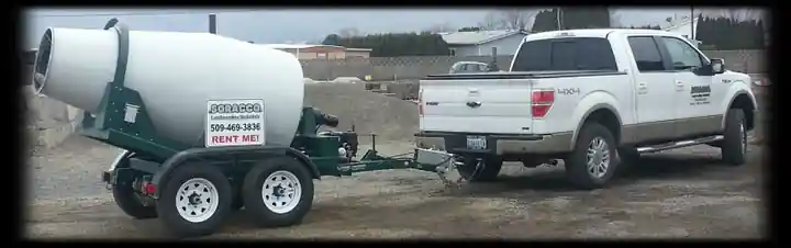 Tow-behind concrete mixer trailer hitched to a pickup